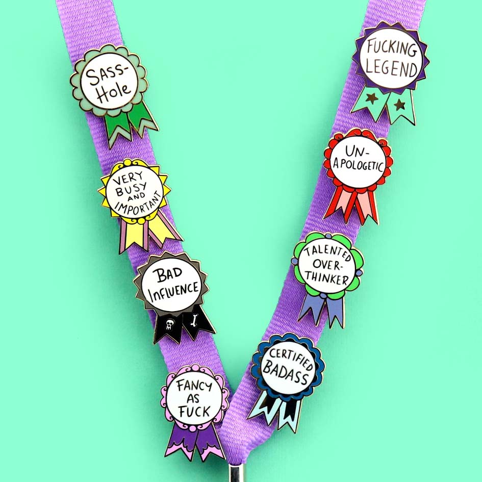 Bad Influence Lapel Pin on a lanyard with other pins