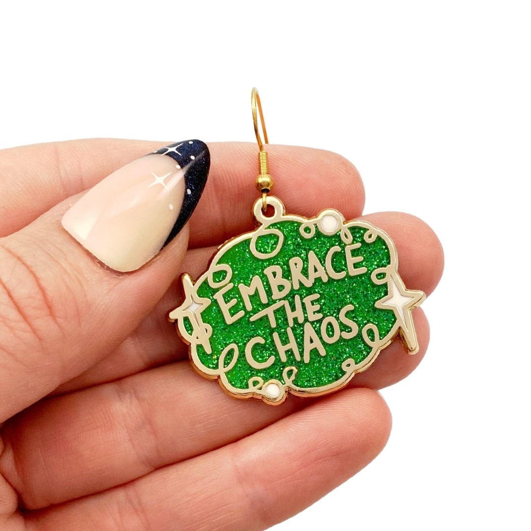 Embrace the chaos earring being held