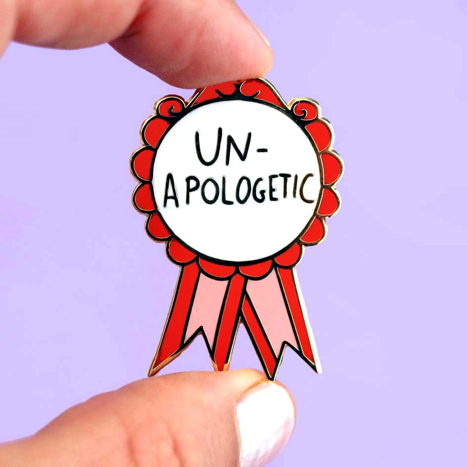 Un-Apologetic Lapel Pin held by fingers